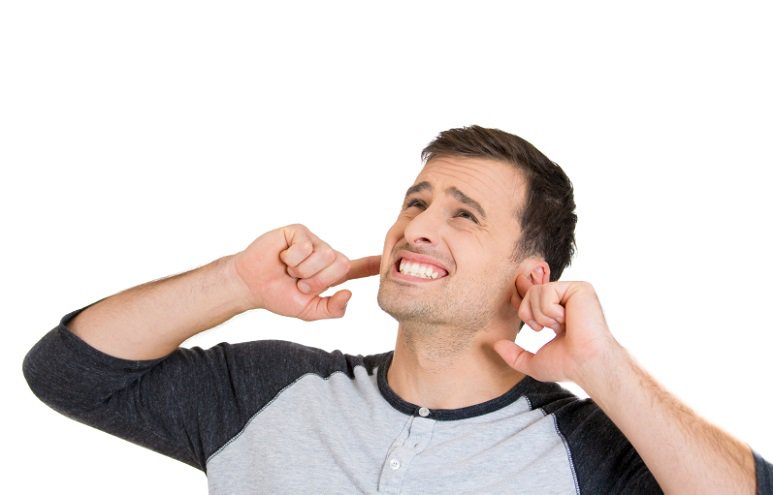 unhappy man covering ears